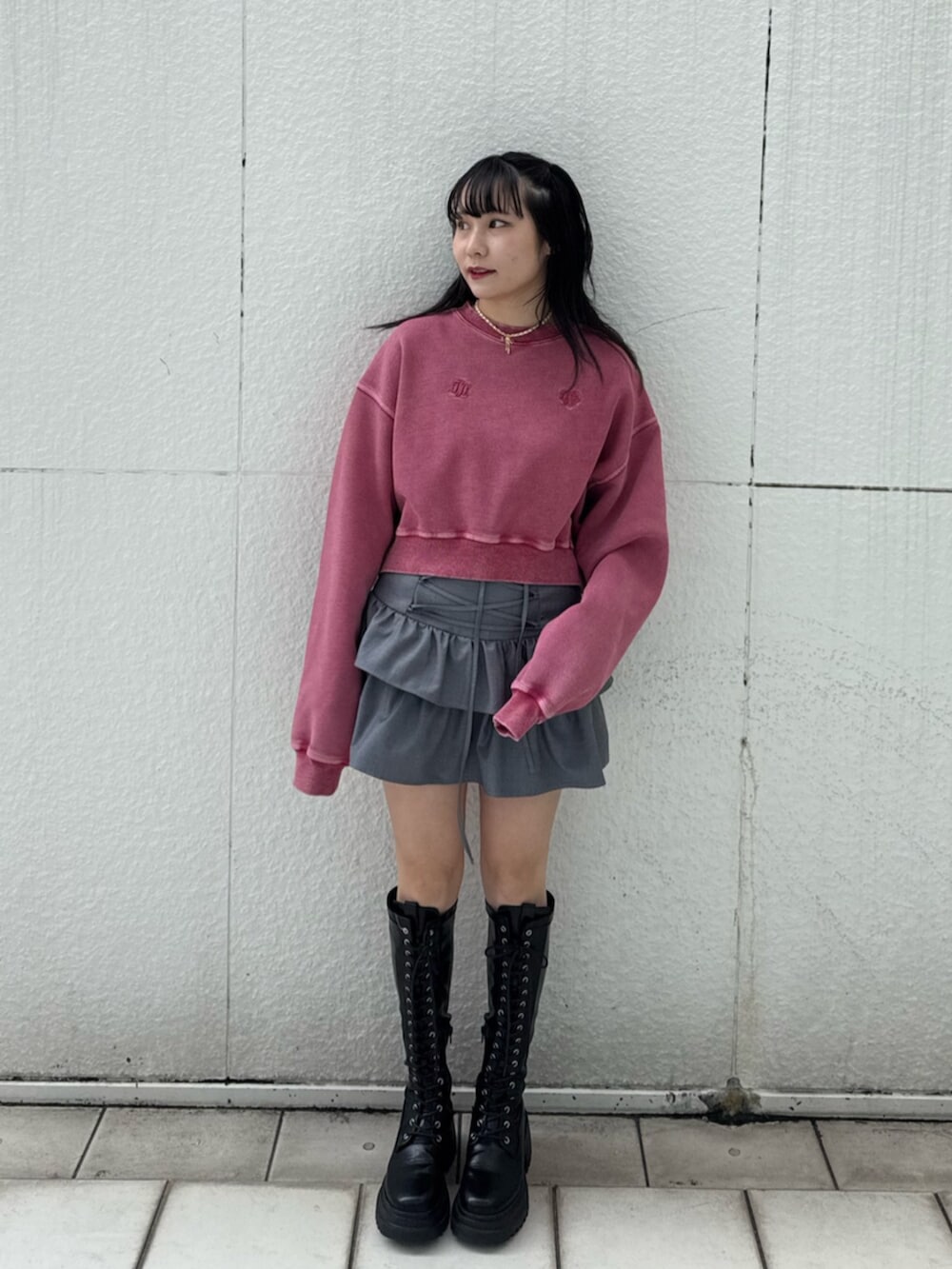 ブラック系のブーツ、ピンク系のスウェット、グレー系のスカートを着用したレディースの冬コーディネートの4枚目の写真