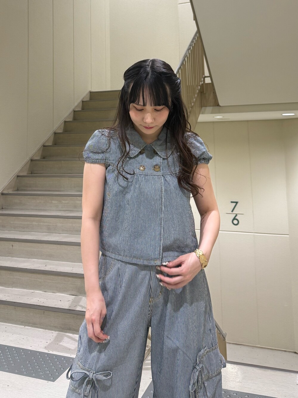 ブラック系のデニムパンツ、ブラック系のブーツ、ブラック系のその他トップスを着用したレディースの春コーディネートの8枚目の写真