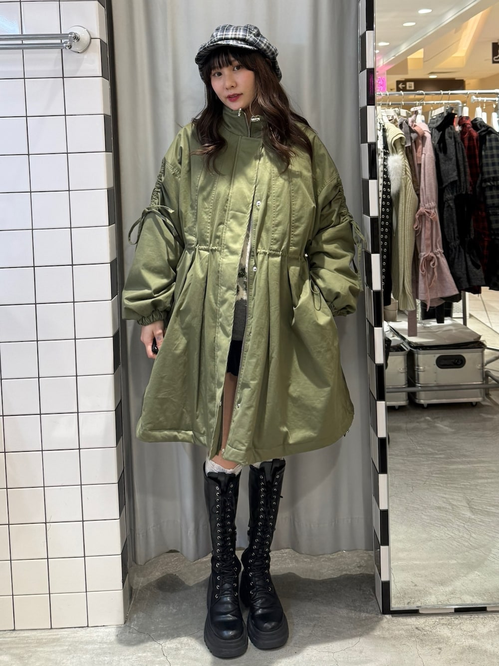 グリーン系のモッズコート、グレー系のニット/セーター、ブルー系のスカートを着用したレディースの冬コーディネートの6枚目の写真