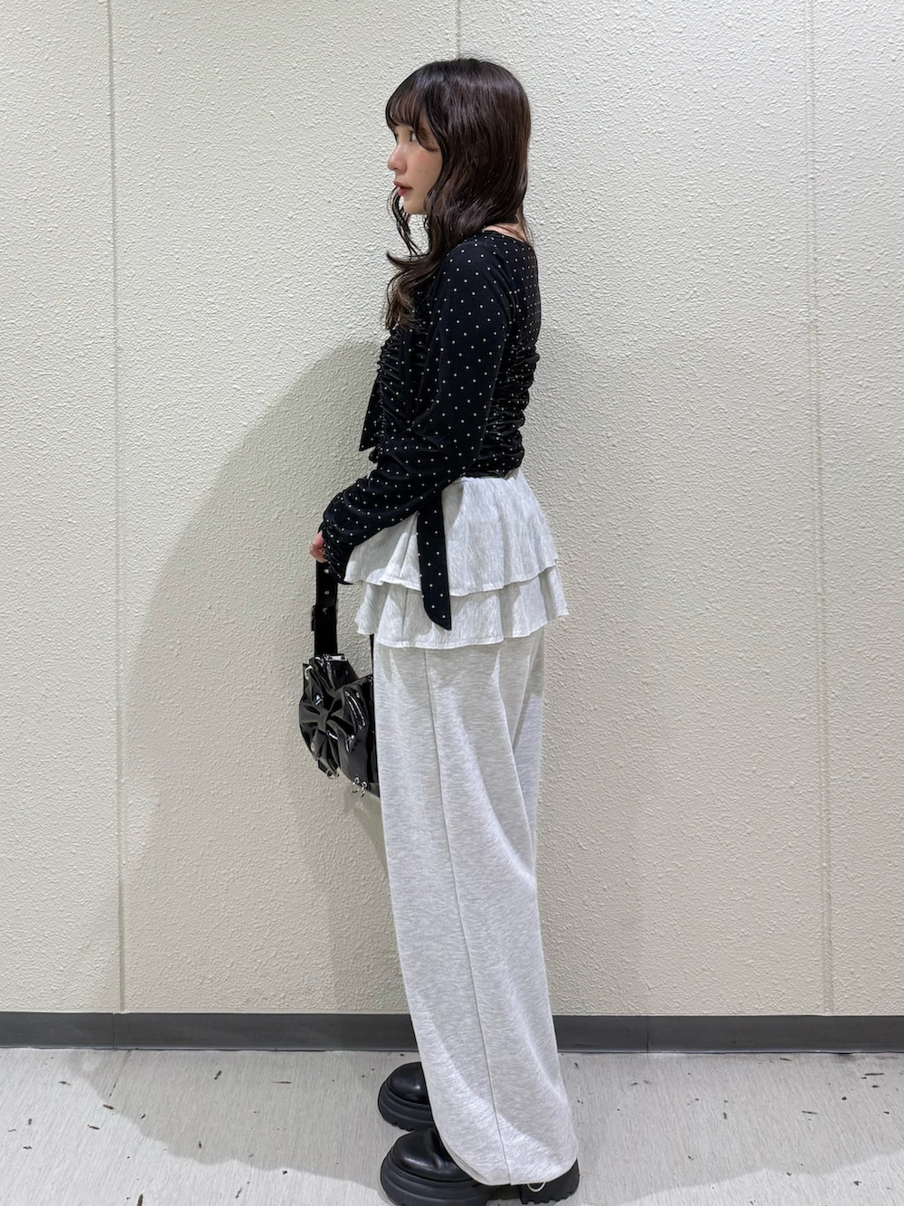 ブラック系のTシャツ/カットソー、グレー系のスウェットパンツ、ブラック系のショルダーバッグを着用したレディースの冬コーディネートの2枚目の写真