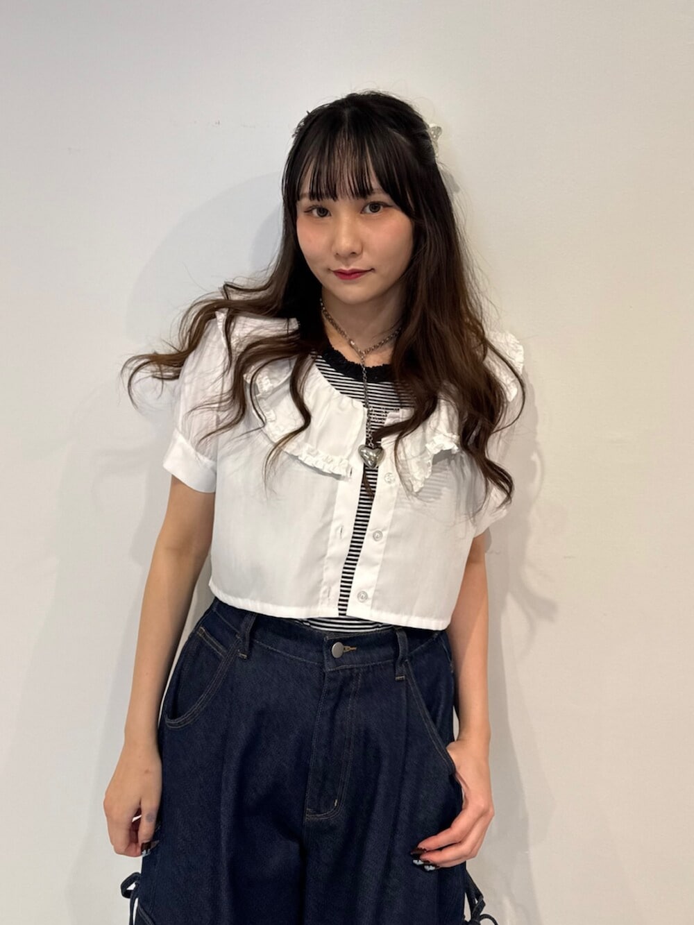 ブラック系のパンプス、ホワイト系のシャツ/ブラウス、ブルー系のデニムパンツを着用したレディースの春コーディネートの6枚目の写真