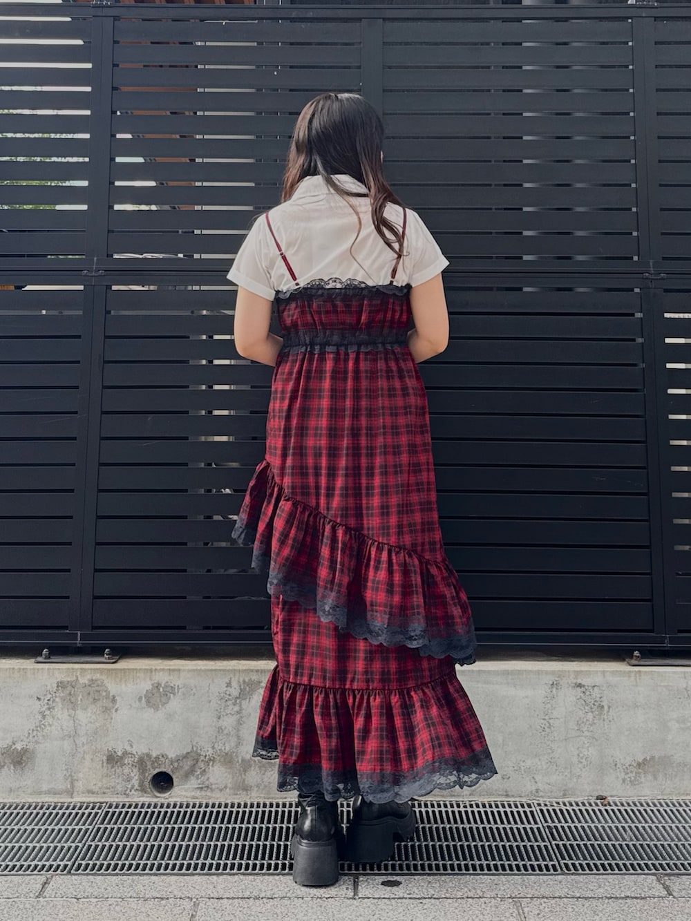 レッド系のワンピース、ブラック系のブーツ、ホワイト系のシャツ/ブラウスを着用したレディースの夏コーディネートの3枚目の写真