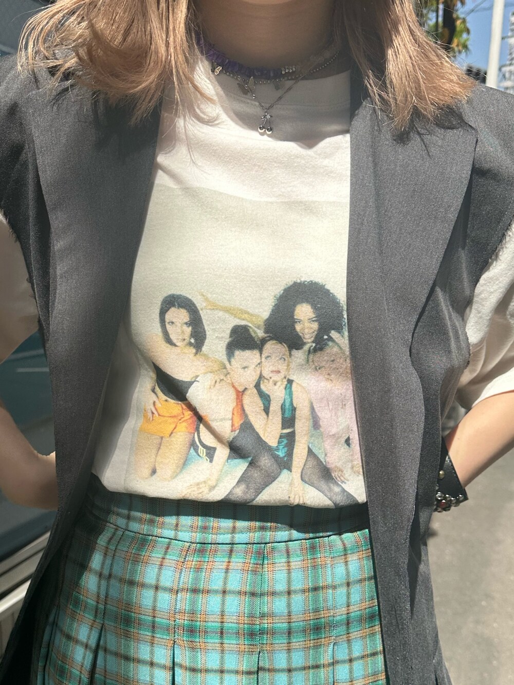 グリーン系のスカート、グレー系のベスト、ホワイト系のTシャツ/カットソーを着用したレディースの春コーディネートの5枚目の写真