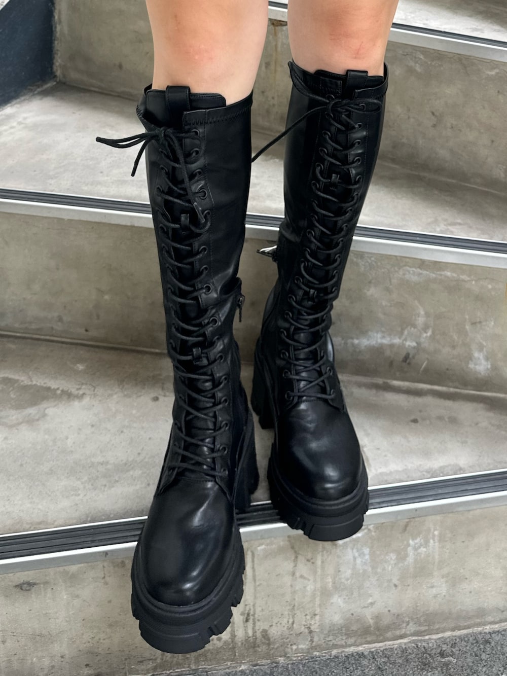 グリーン系のカーディガン/ボレロ、ブラック系のブーツ、シルバー系のネックレスを着用したレディースの秋コーディネートの7枚目の写真