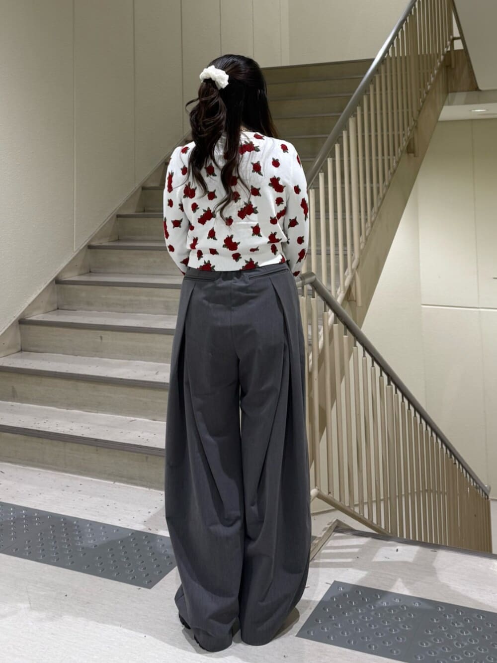 グレー系のスラックス、ホワイト系のカーディガン/ボレロ、ブラック系のローファーを着用したレディースの冬コーディネートの5枚目の写真