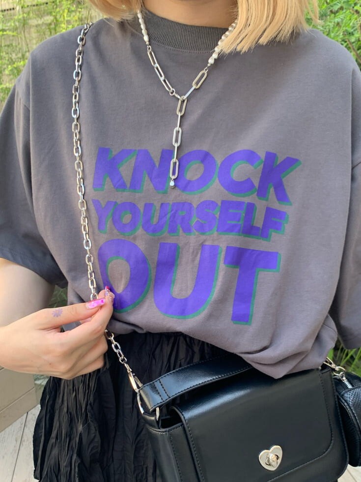 ブラック系のワンピース、ブラック系のハンドバッグ、シルバー系のネックレスを着用したレディースの夏コーディネートの5枚目の写真