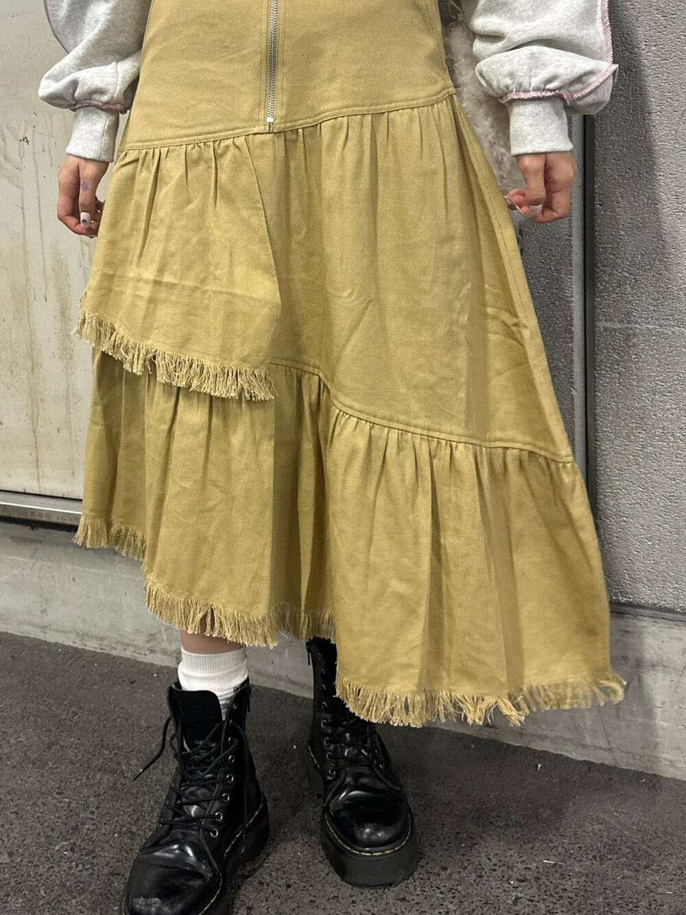 グレー系のスウェット、ホワイト系のハンドバッグ、ベージュ系のスカートを着用したレディースの冬コーディネートの7枚目の写真