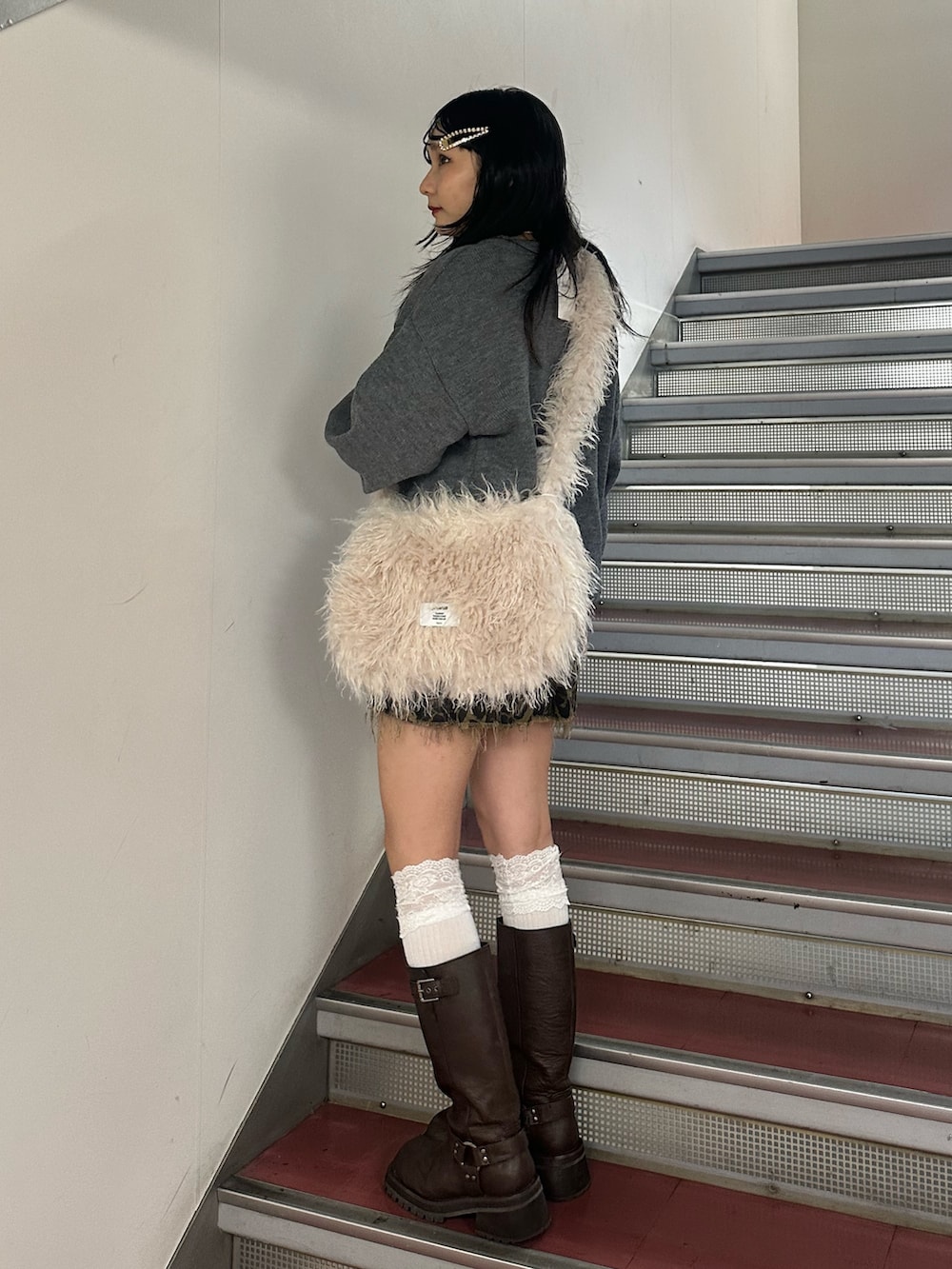 ホワイト系のショルダーバッグ、グレー系のニット/セーター、ブラウン系のその他パンツを着用したレディースの冬コーディネートの3枚目の写真