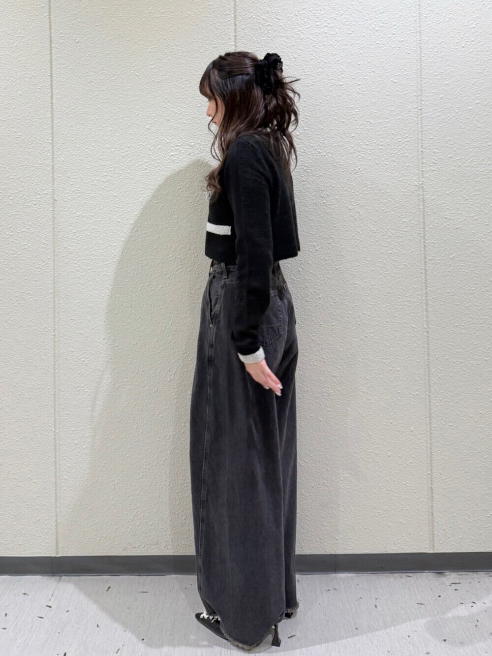 ブラック系のパンプス、ブラック系のカーディガン/ボレロ、ブラック系のデニムパンツを着用したレディースの秋コーディネートの3枚目の写真