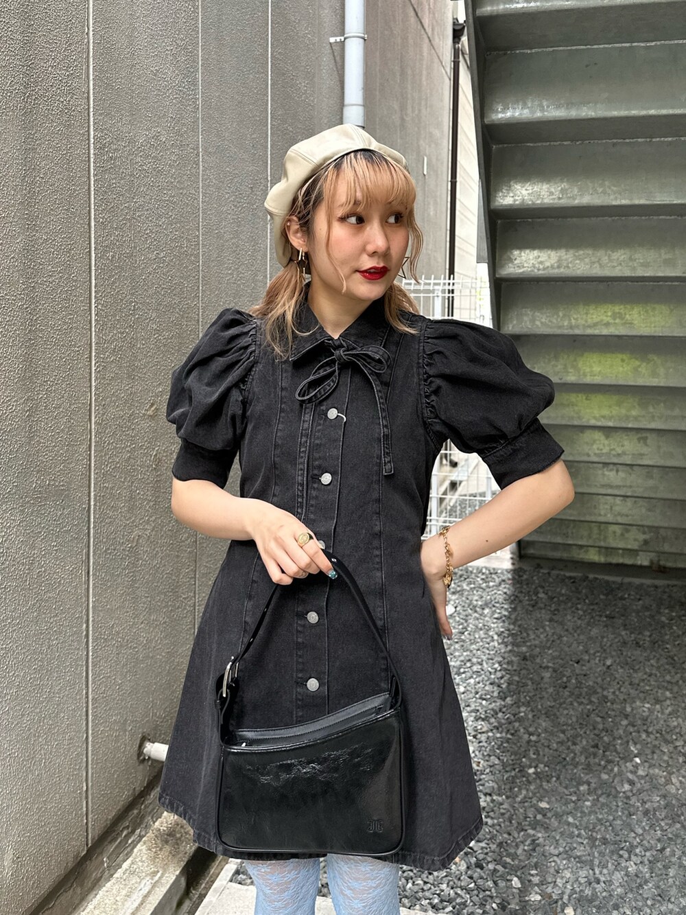 ブラック系のワンピース、ブラック系のハンドバッグ、ゴールド系のピアス（両耳用）を着用したレディースの春コーディネートの4枚目の写真