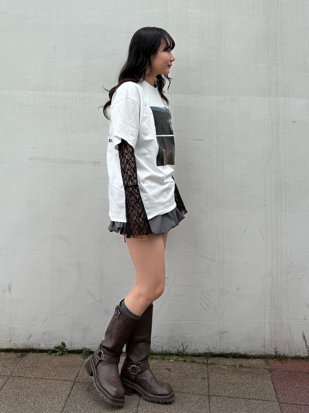 グレー系のスカート、ホワイト系のTシャツ/カットソー、ブラック系のTシャツ/カットソーを着用したレディースの春コーディネートの2枚目の写真