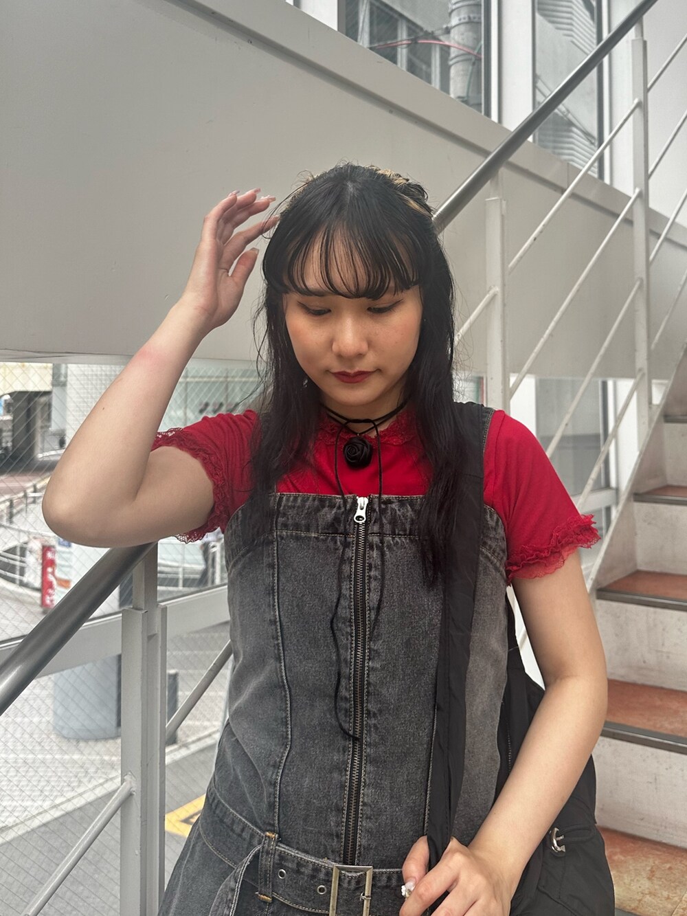 レッド系のTシャツ/カットソー、ブラック系のワンピース、ブラック系のショルダーバッグを着用したレディースの夏コーディネートの4枚目の写真