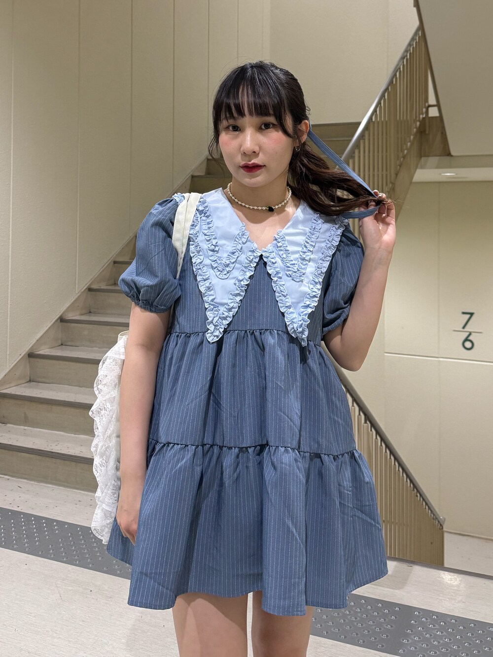 ブルー系のワンピース、ブラック系のブーツ、ホワイト系のトートバッグを着用したレディースの春コーディネートの8枚目の写真