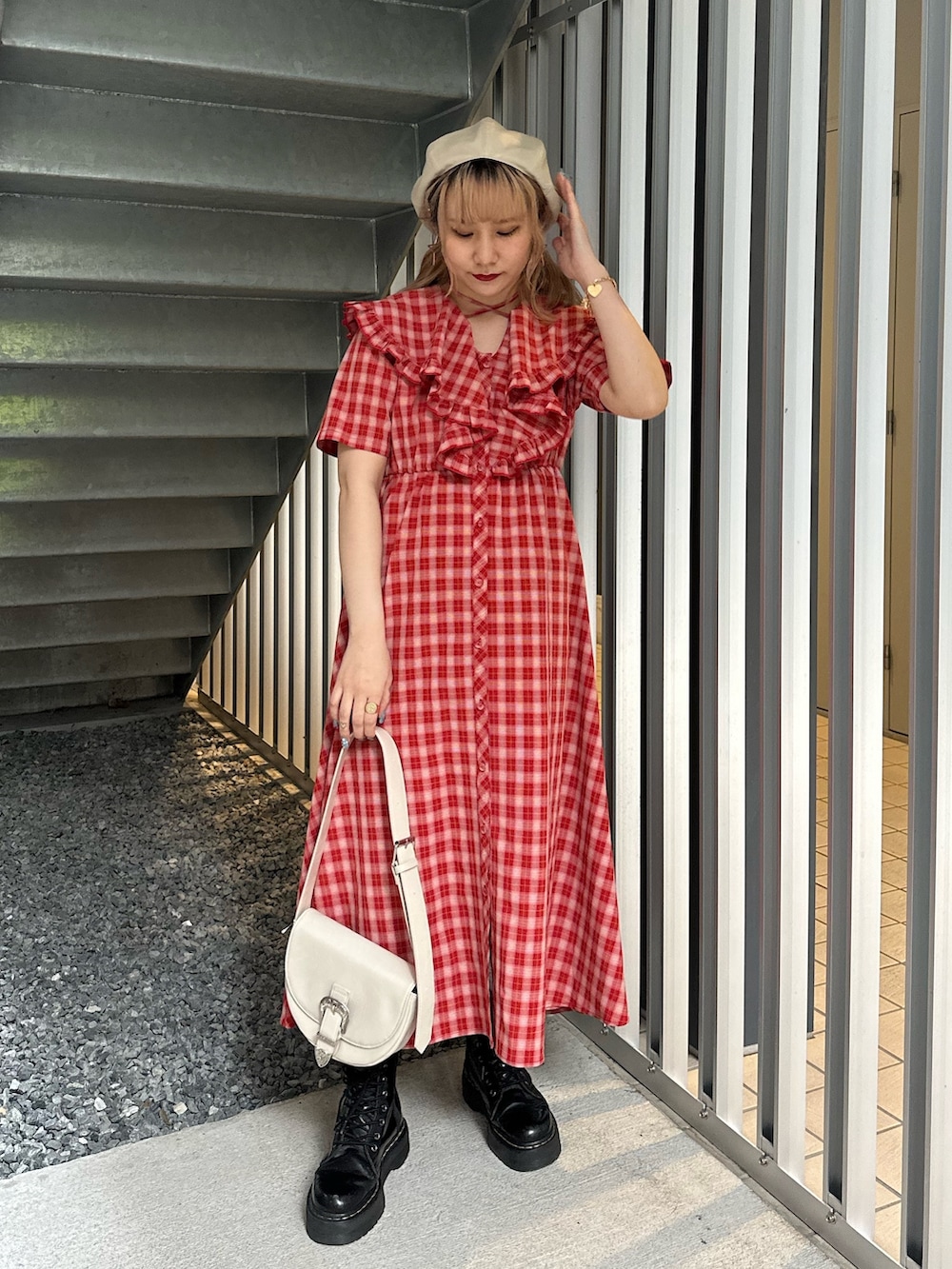 レッド系のワンピース、ホワイト系のショルダーバッグ、ホワイト系のハンチング/ベレー帽を着用したレディースの春コーディネートの2枚目の写真