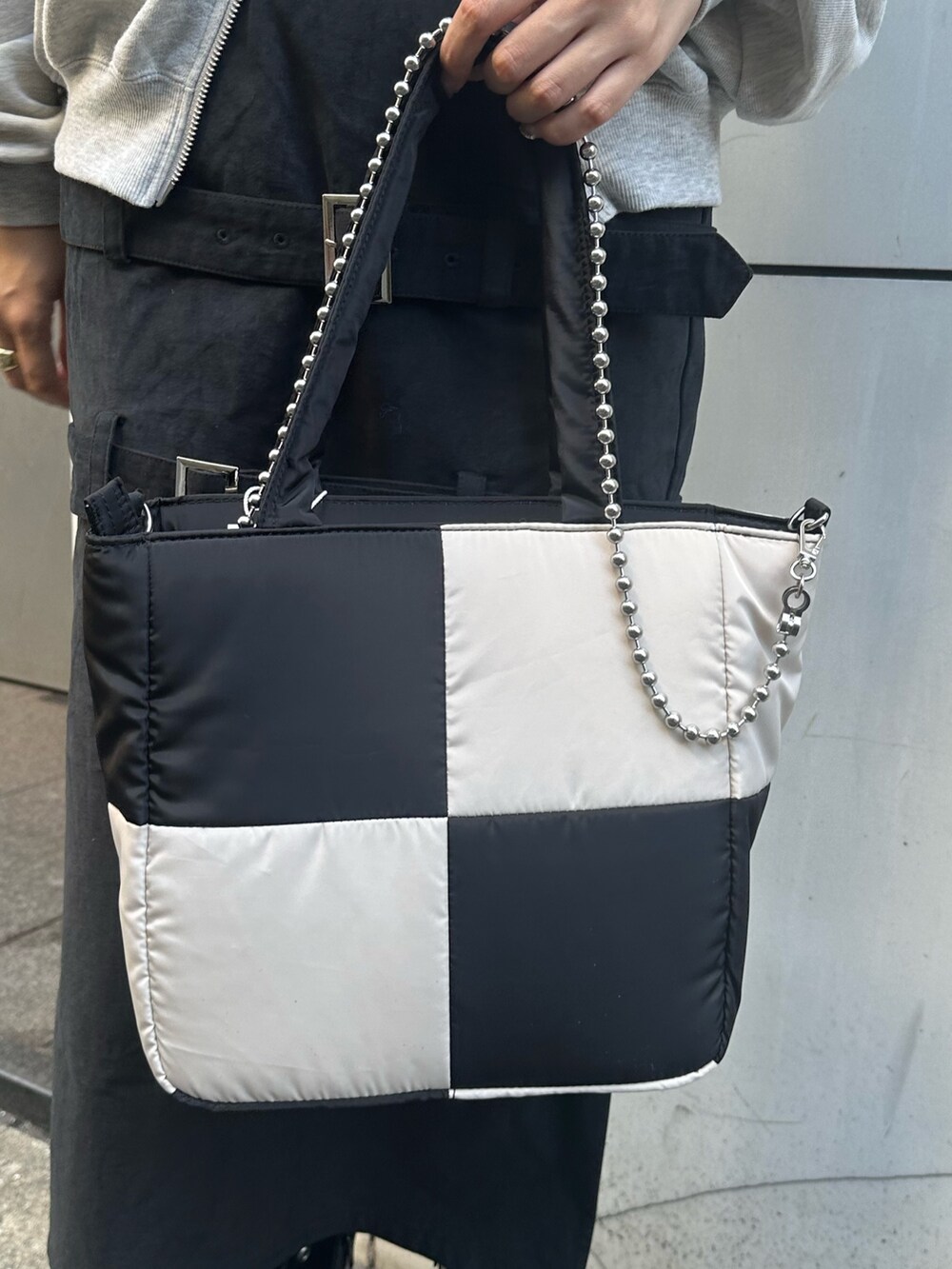 グレー系のスウェット、ブラック系のスカート、ブラック系のハンドバッグを着用したレディースの秋コーディネートの8枚目の写真