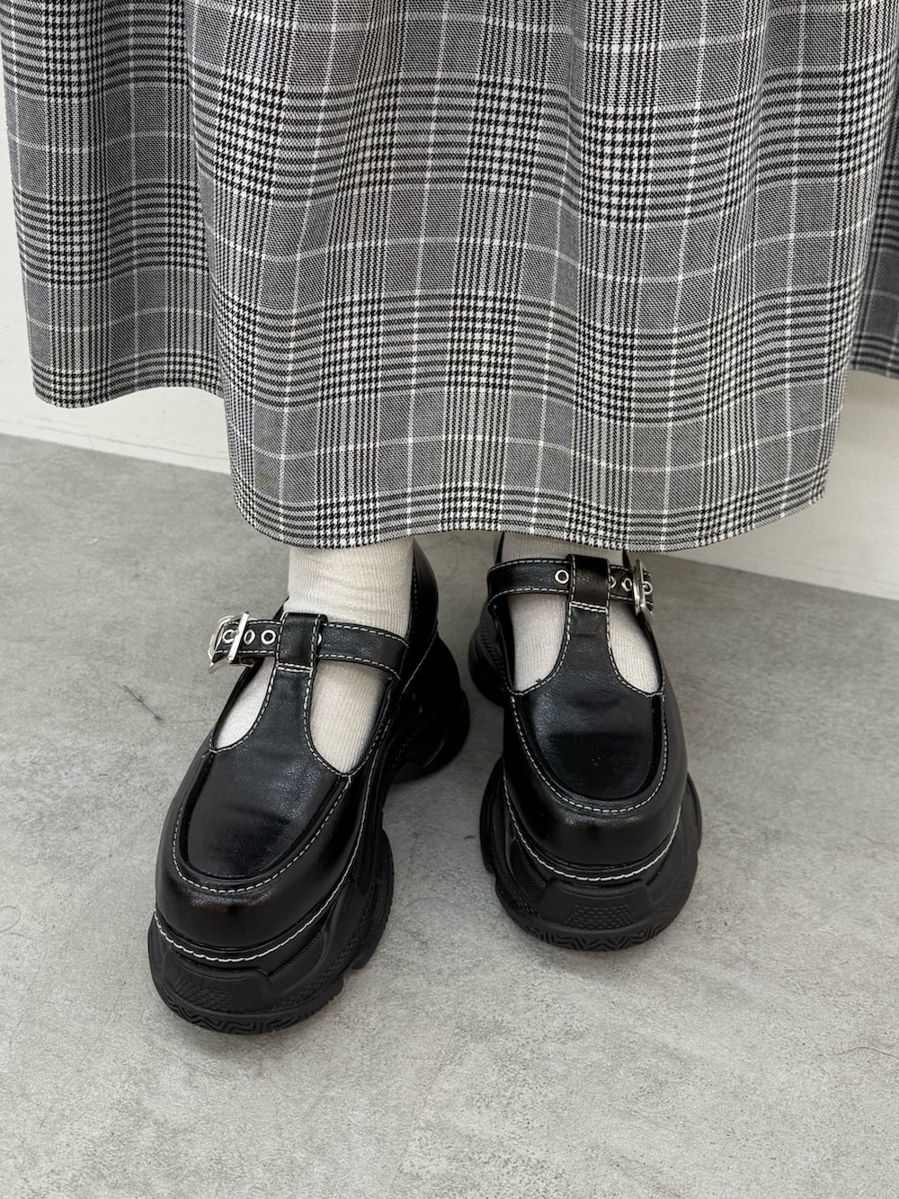 ブルー系のジャージ、グレー系のスカート、ブラック系のスニーカーを着用したレディースの春コーディネートの7枚目の写真