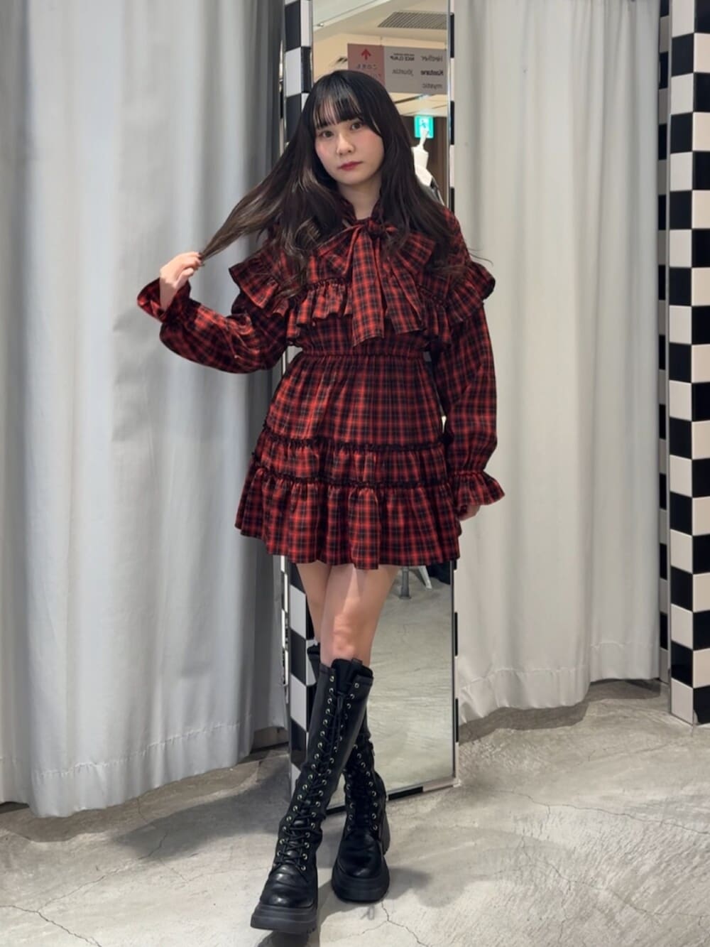 ブラック系のブーツ、レッド系のワンピースを着用したレディースの冬コーディネートの6枚目の写真