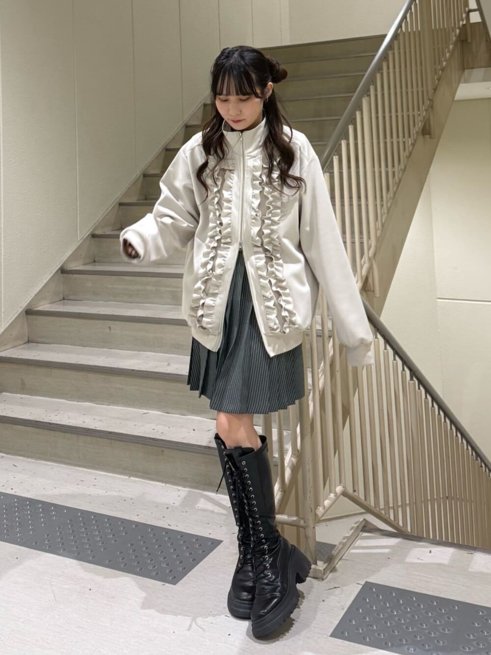 ブラック系のブーツ、ホワイト系のジャージ、その他のスカートを着用したレディースの冬コーディネートの7枚目の写真