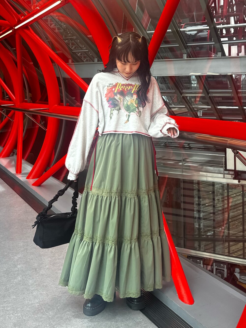 グレー系のスウェット、グリーン系のスカート、ブラック系のショルダーバッグを着用したレディースの夏コーディネートの4枚目の写真