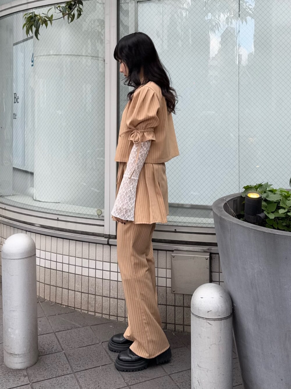 ブラック系のブーツ、ホワイト系のTシャツ/カットソー、ベージュ系のテーラードジャケットを着用したレディースの冬コーディネートの2枚目の写真