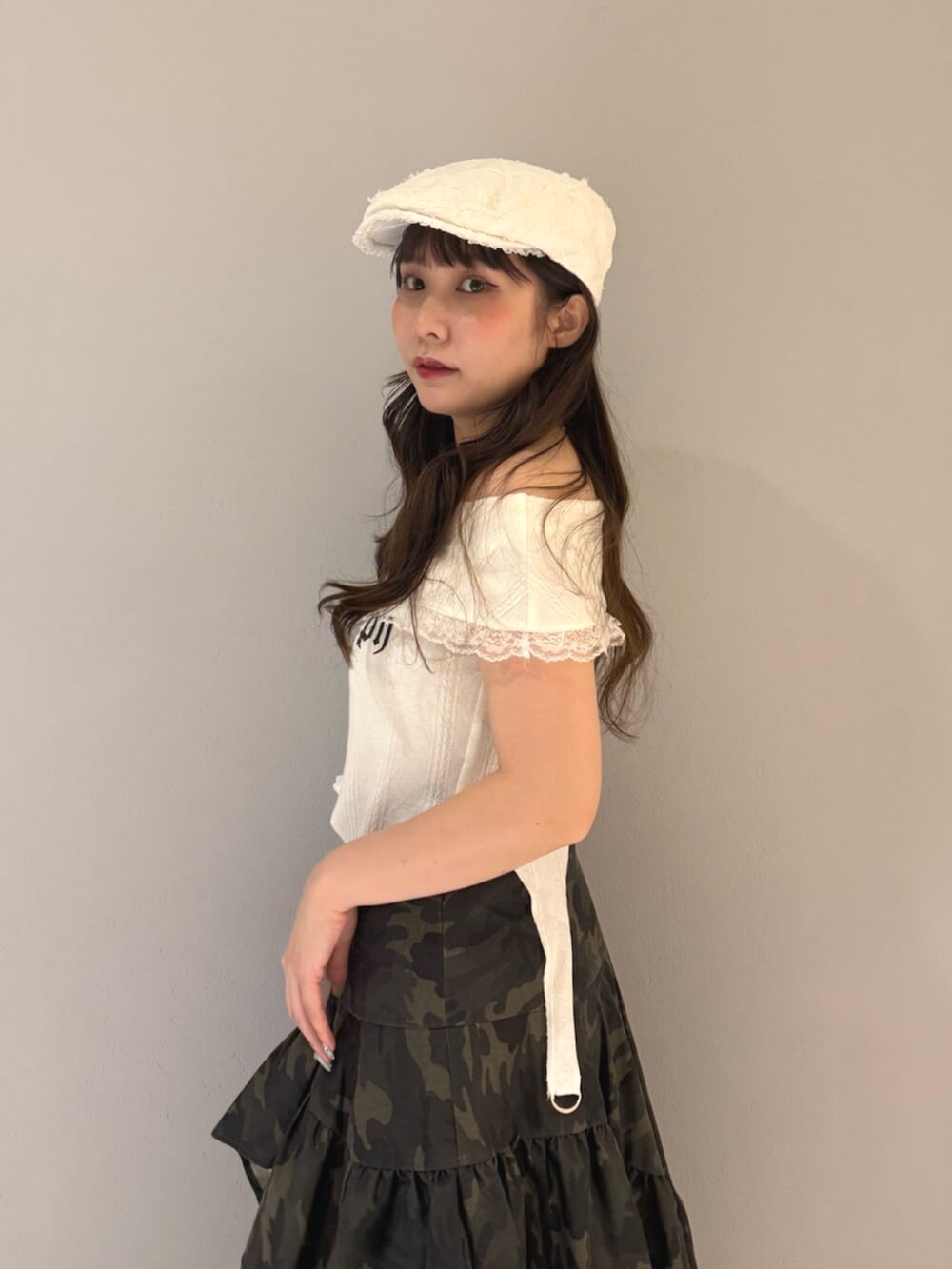 ブラック系のブーツ、ホワイト系のTシャツ/カットソー、グリーン系のスカートを着用したレディースの夏コーディネートの6枚目の写真