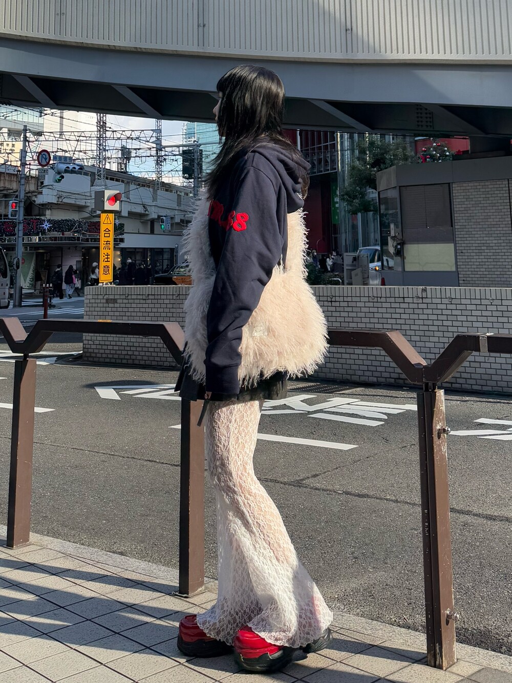 ブルー系のパーカー、ホワイト系のショルダーバッグ、ブラック系のスカートを着用したレディースの冬コーディネートの2枚目の写真