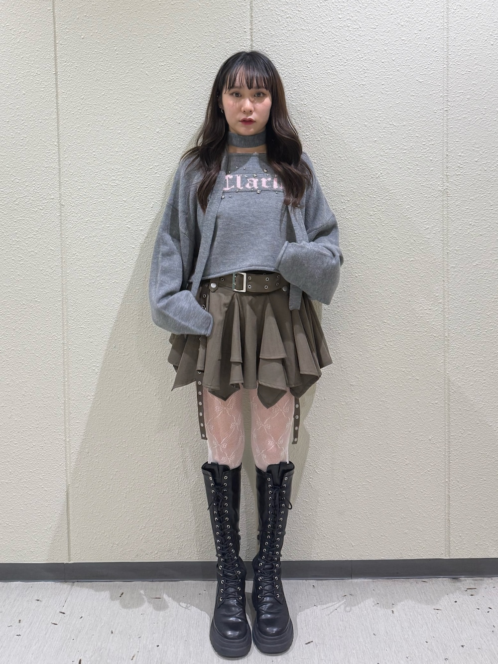 ベージュ系のスカート、グレー系のニット/セーター、ブラック系のブーツを着用したレディースの冬コーディネートの4枚目の写真