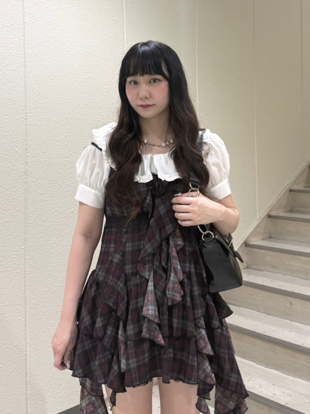 ホワイト系のシャツ/ブラウス、ブラック系のハンドバッグ、ブラック系のブーツを着用したレディースの夏コーディネートの6枚目の写真