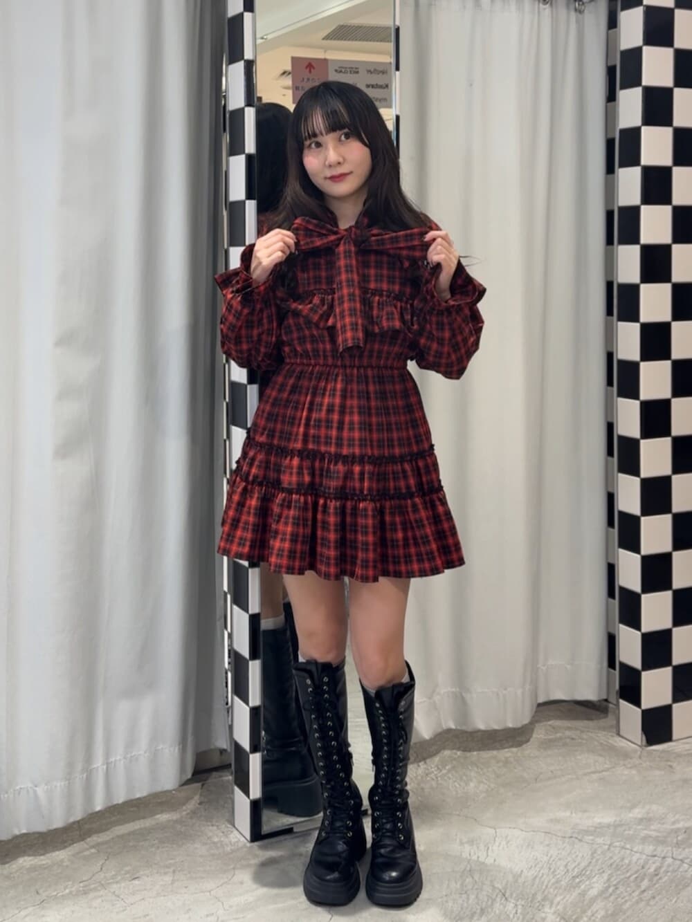 ブラック系のブーツ、レッド系のワンピースを着用したレディースの冬コーディネートの3枚目の写真