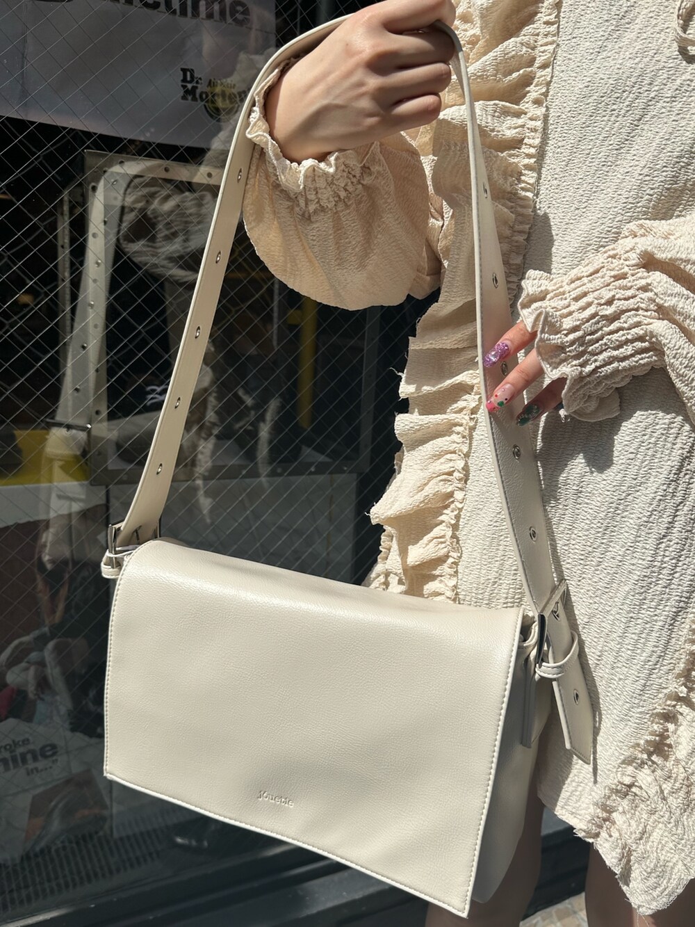 ブルー系のデニムパンツ、ホワイト系のシャツ/ブラウス、ホワイト系のメッセンジャーバッグを着用したレディースの春コーディネートの6枚目の写真