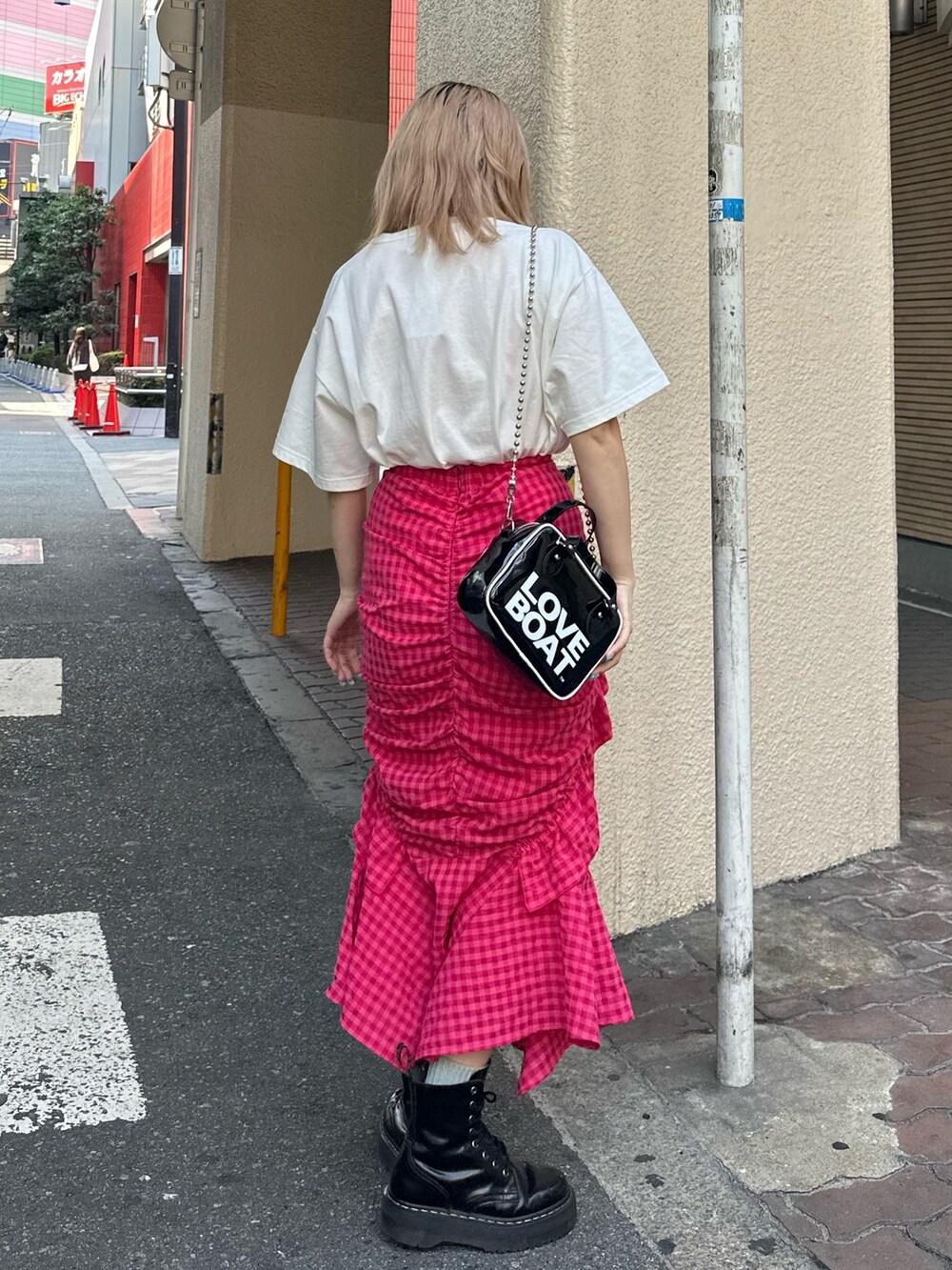 ブラック系のブーツ、ホワイト系のTシャツ/カットソー、ピンク系のスカートを着用したレディースの春コーディネートの3枚目の写真