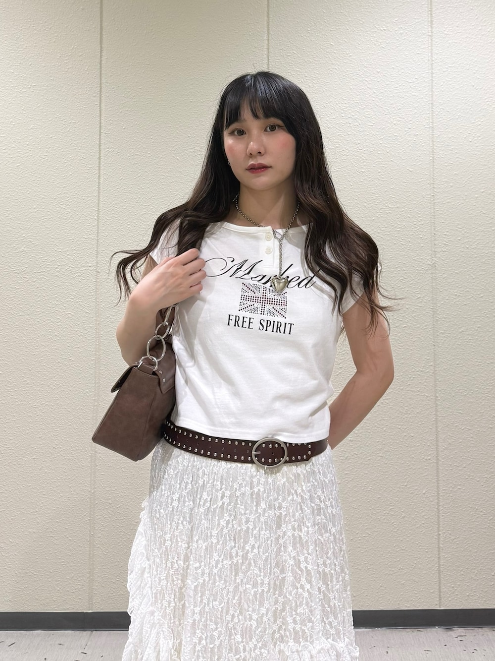 ブラック系のブーツ、ホワイト系のスカート、ホワイト系のTシャツ/カットソーを着用したレディースの春コーディネートの6枚目の写真