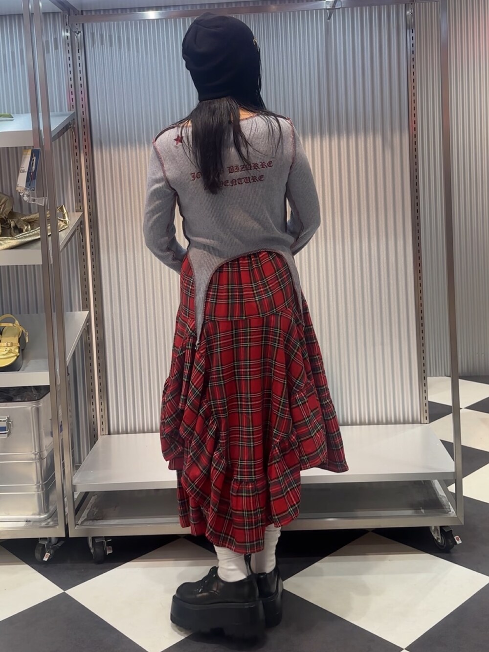 ブルー系のTシャツ/カットソー、レッド系のスカート、ブラック系のドレスシューズを着用したレディースの秋コーディネートの4枚目の写真