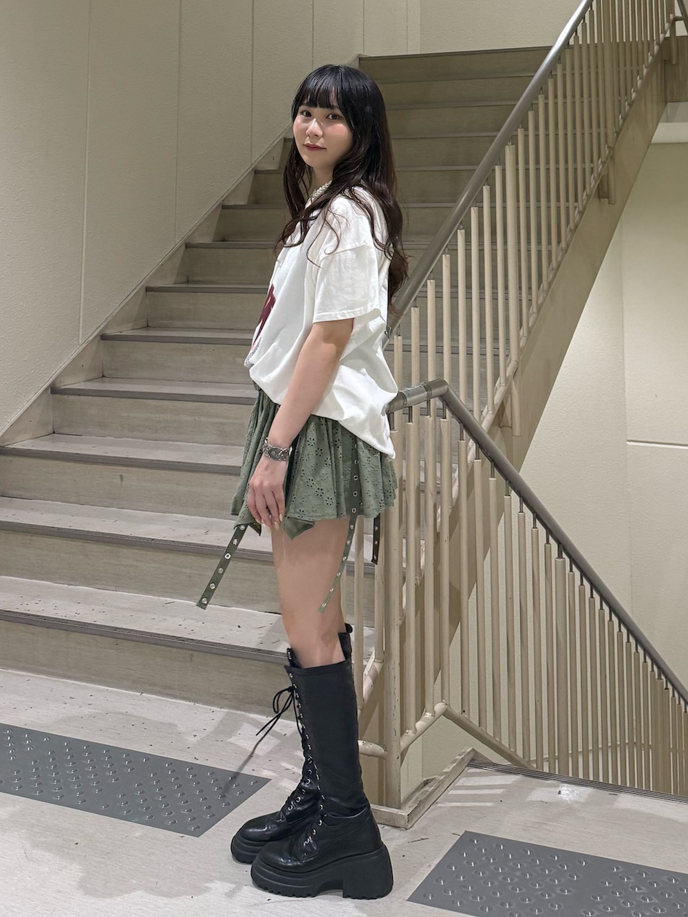 ホワイト系のTシャツ/カットソー、ブラック系のブーツ、グリーン系のスカートを着用したレディースの春コーディネートの3枚目の写真