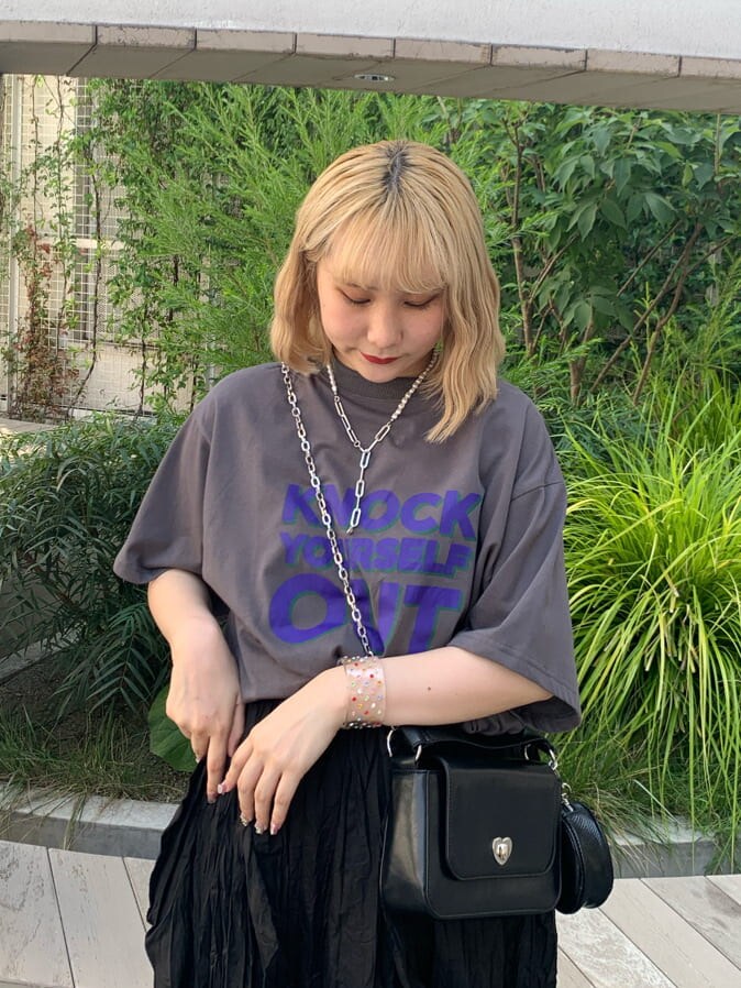 ブラック系のワンピース、ブラック系のハンドバッグ、シルバー系のネックレスを着用したレディースの夏コーディネートの4枚目の写真