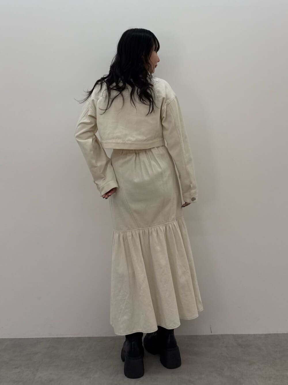 ブラック系のブーツ、ホワイト系のワンピース、ブルー系のTシャツ/カットソーを着用したレディースの春コーディネートの4枚目の写真