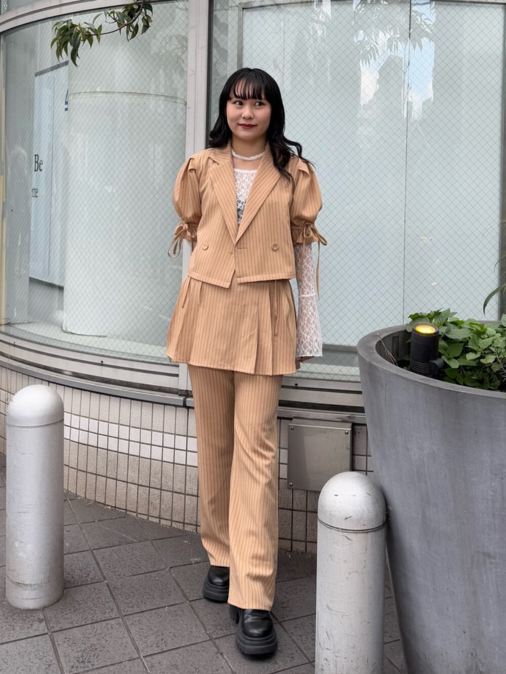 ブラック系のブーツ、ホワイト系のTシャツ/カットソー、ベージュ系のテーラードジャケットを着用したレディースの冬コーディネートの4枚目の写真