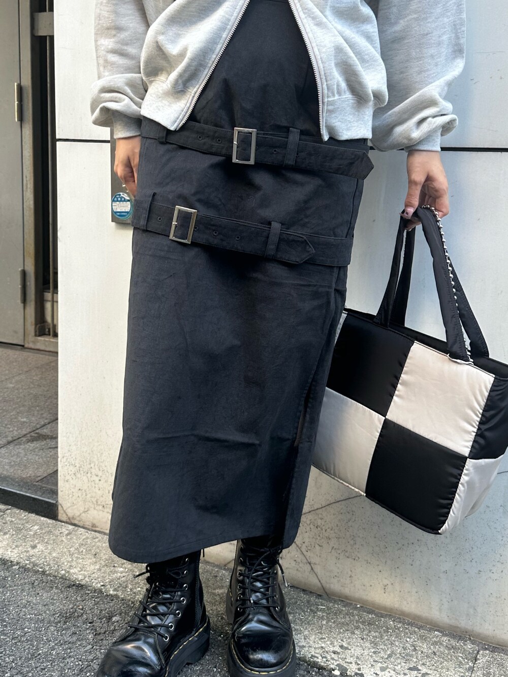 グレー系のスウェット、ブラック系のスカート、ブラック系のハンドバッグを着用したレディースの秋コーディネートの7枚目の写真