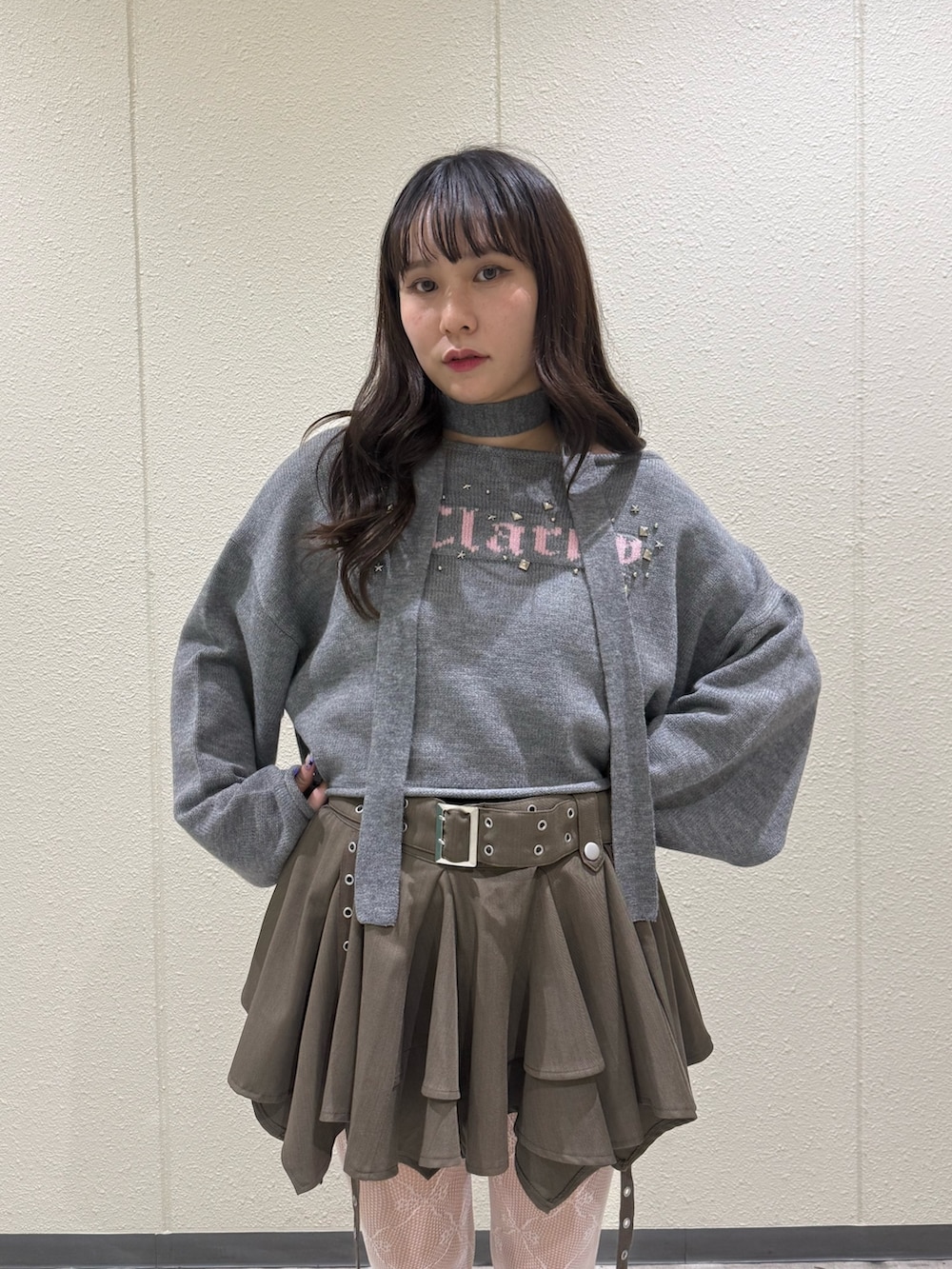 ベージュ系のスカート、グレー系のニット/セーター、ブラック系のブーツを着用したレディースの冬コーディネートの7枚目の写真