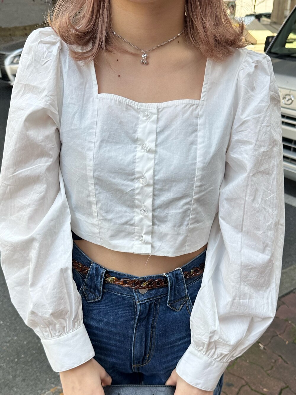 ホワイト系のシャツ/ブラウス、ブルー系のデニムパンツ、ブラック系のショルダーバッグを着用したレディースの春コーディネートの5枚目の写真