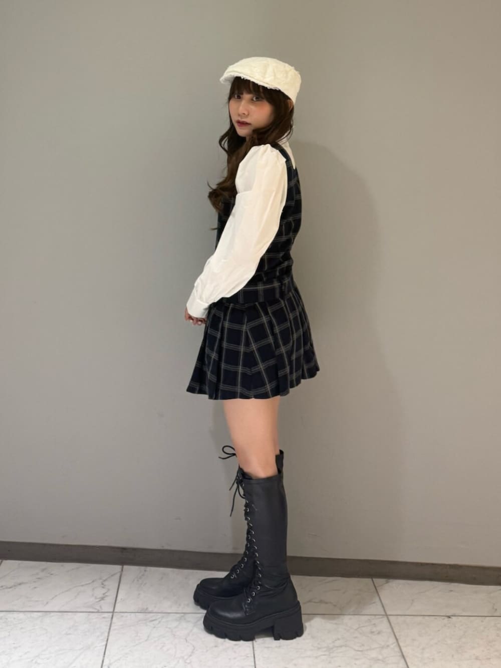 ブラック系のブーツ、ブルー系のワンピース、ホワイト系のハンチング/ベレー帽を着用したレディースの夏コーディネートの2枚目の写真