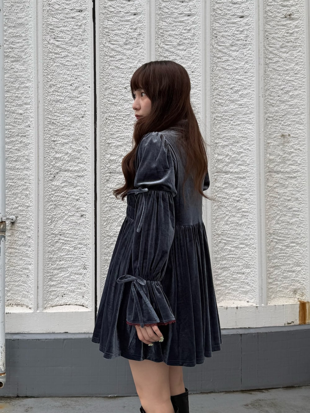 ブルー系のワンピース、ブラック系のブーツを着用したレディースの秋コーディネートの5枚目の写真