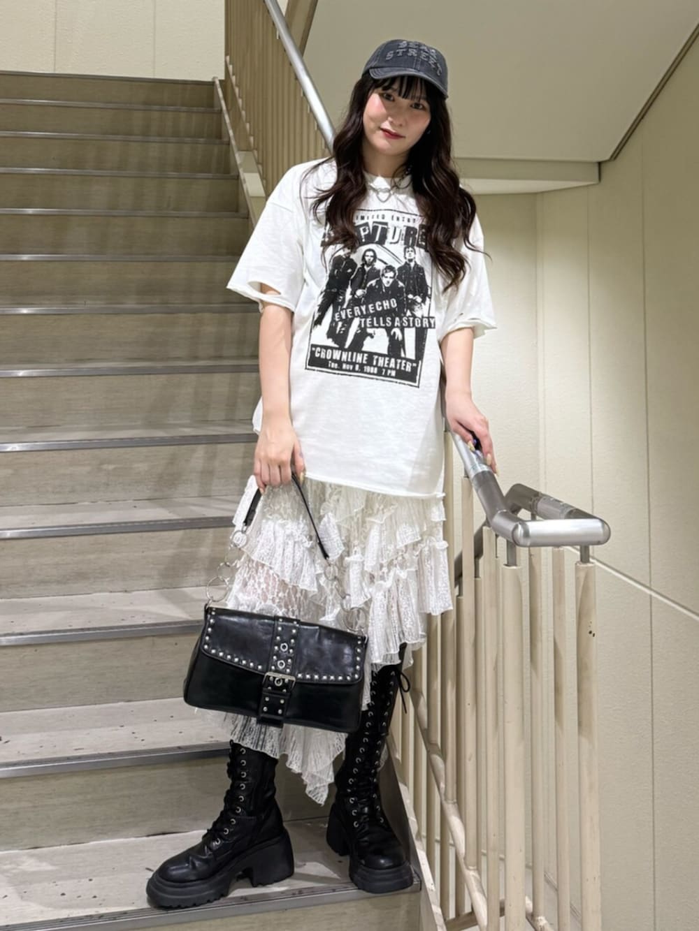 ブラック系のブーツ、ホワイト系のTシャツ/カットソー、ブラック系のハンドバッグを着用したレディースの春コーディネートの4枚目の写真