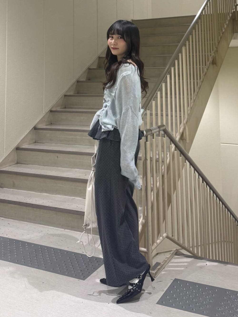 ブルー系のニット/セーター、グレー系のスウェットパンツ、ブラック系のパンプスを着用したレディースの春コーディネートの4枚目の写真