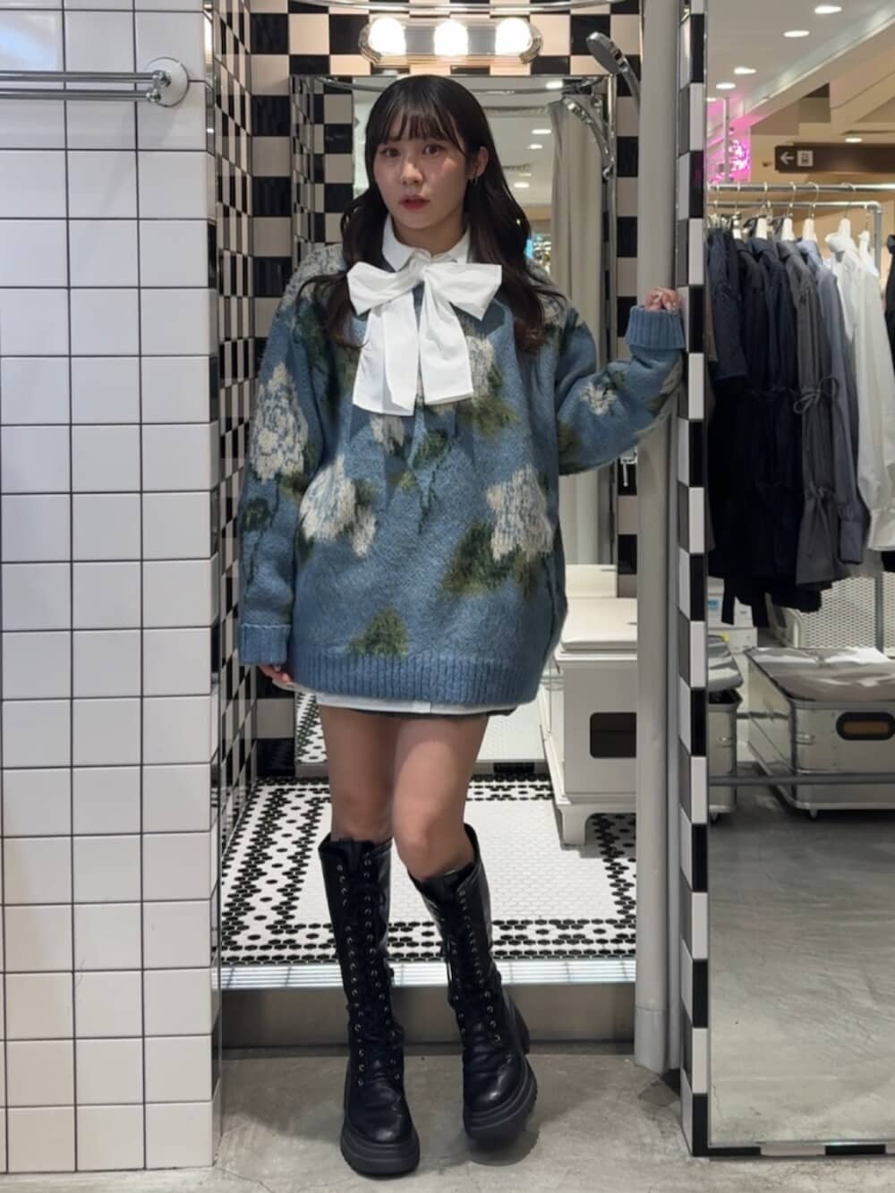 ブラック系のブーツ、ホワイト系のシャツ/ブラウス、ブルー系のニット/セーターを着用したレディースの冬コーディネートの4枚目の写真