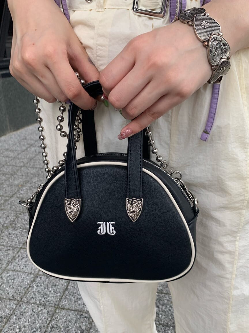 ブラック系のボストンバッグ、ホワイト系のその他パンツ、パープル系のTシャツ/カットソーを着用したレディースの夏コーディネートの8枚目の写真