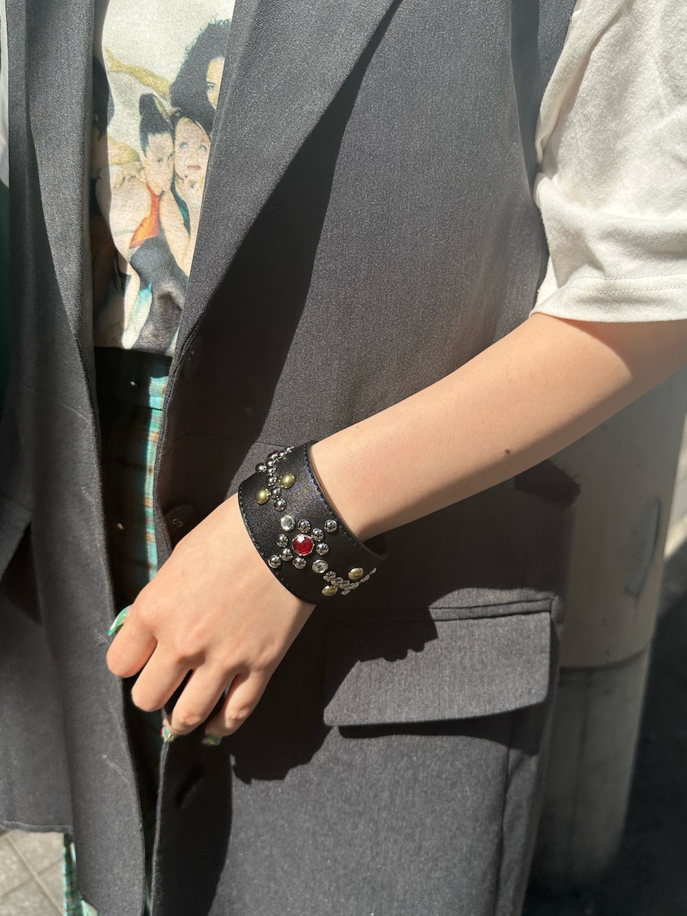 グリーン系のスカート、グレー系のベスト、ホワイト系のTシャツ/カットソーを着用したレディースの春コーディネートの7枚目の写真