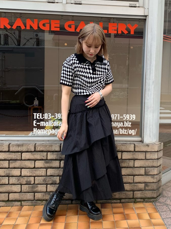 ブラック系のニット/セーター、ブラック系のスカート、シルバー系のブレスレットを着用したレディースの春コーディネートの2枚目の写真