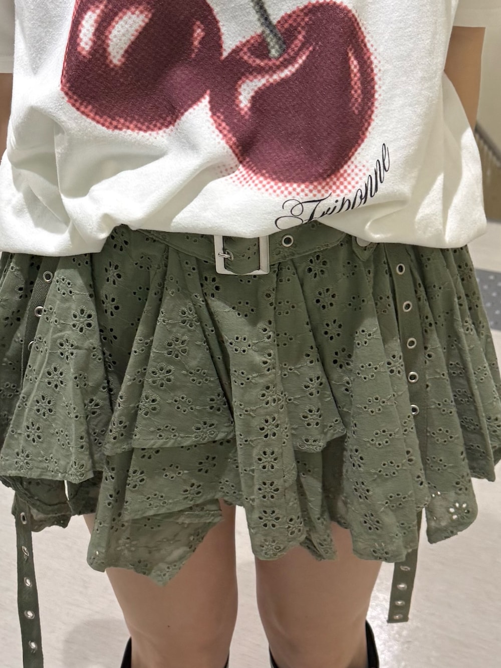 ホワイト系のTシャツ/カットソー、ブラック系のブーツ、グリーン系のスカートを着用したレディースの春コーディネートの8枚目の写真