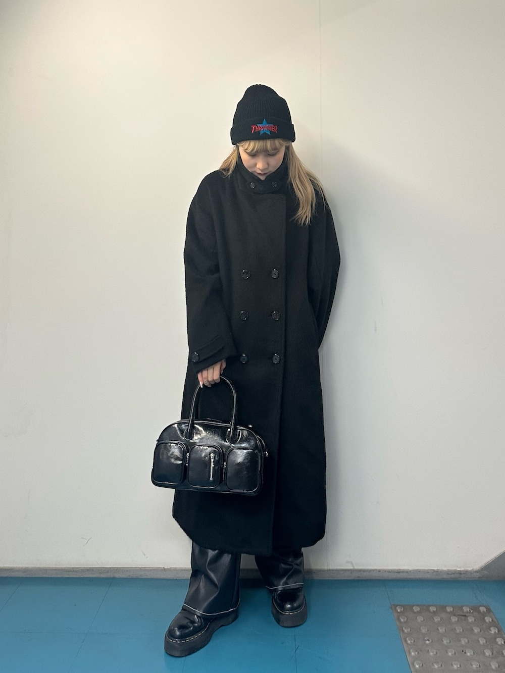 グリーン系のニット/セーター、その他のチェスターコート、ブラック系のボストンバッグを着用したレディースの冬コーディネートの2枚目の写真